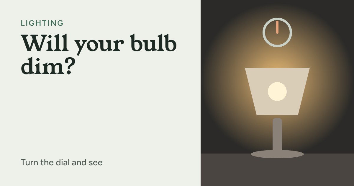 A table lamp glowing warmly in a dark room with a dimmer dial above it